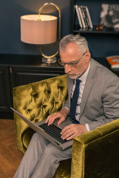 Ocupado hombre mayor concentrado escribiendo en el portátil — Foto de Stock