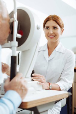 Çalışma sırasında kırmızı saçlı gülen Oftalmolog iyi hissediyor