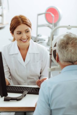 İyi duygu gülümseyen göz uzmanı emekli adam danışmanlık ederken