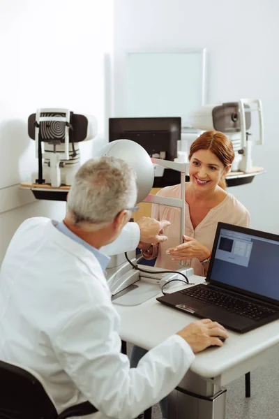 Paziente di clinica oculistica privata sorridente mentre parla con il medico — Foto Stock