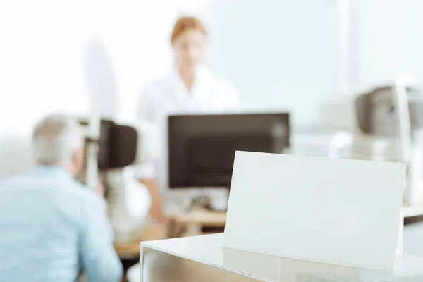 Augenarzt steht bei Untersuchung des Patienten neben Laptop — Stockfoto