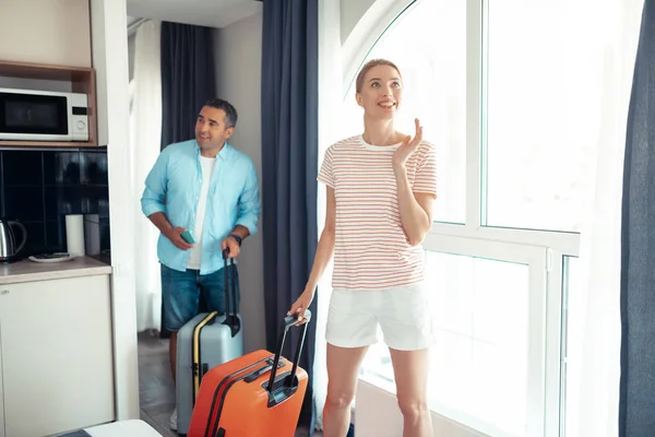 Sorridente donna e suo marito venire in affitto appartamento . — Foto Stock