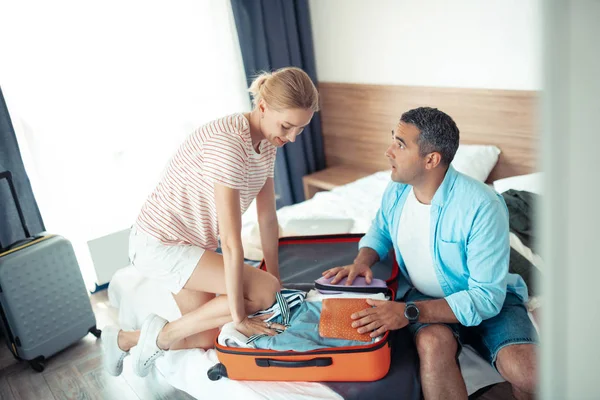 Муж и жена пытаются уменьшить чемодан для путешествий . — стоковое фото