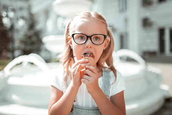 그녀의 초콜릿 아이스크림 콘을 먹는 어린 소녀. — 스톡 사진