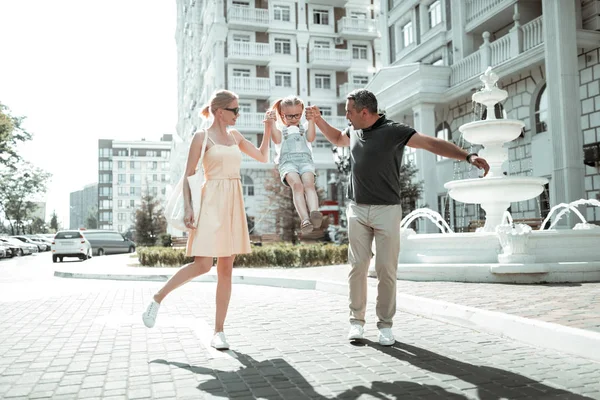 Padres felices caminando con su hijita . — Foto de Stock