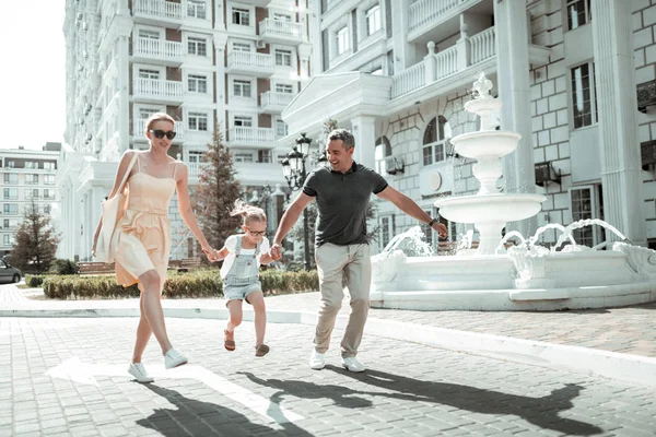 Happy family skipping along the street together. — Stock Photo, Image