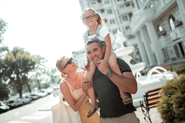Cheerful girl riding her fathers shoulders on the walk. — Stock Photo, Image