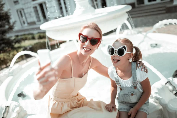 Madre e hija haciendo caras graciosas tomando selfie . —  Fotos de Stock
