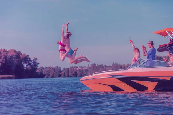 Caucasien jeune femme et homme sautant dans l'eau — Photo