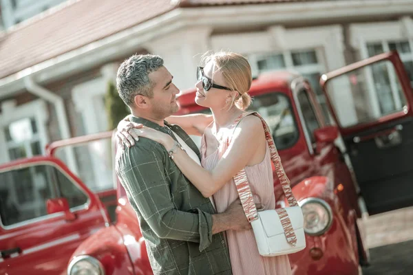 Beautiful couple hugging in front of their car. — Stock Photo, Image
