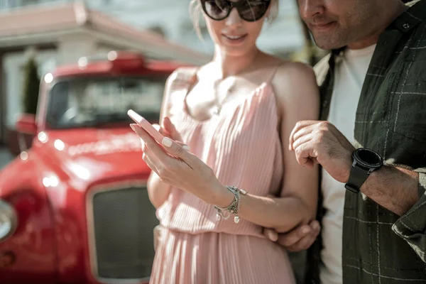 Woman showing her husband pictures on her smartphone. — Stock Photo, Image