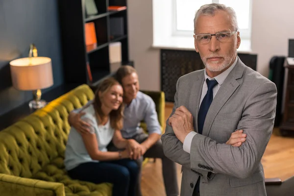 Serieuze, grijs harige, professionele psychotherapeut die in zijn kantoor staat — Stockfoto