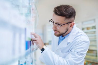 Yeni ilaç arayan konsantre sakallı eczane