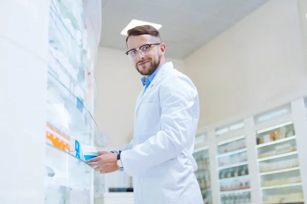 Joyeux homme brune travaillant dans une pharmacie moderne — Photo