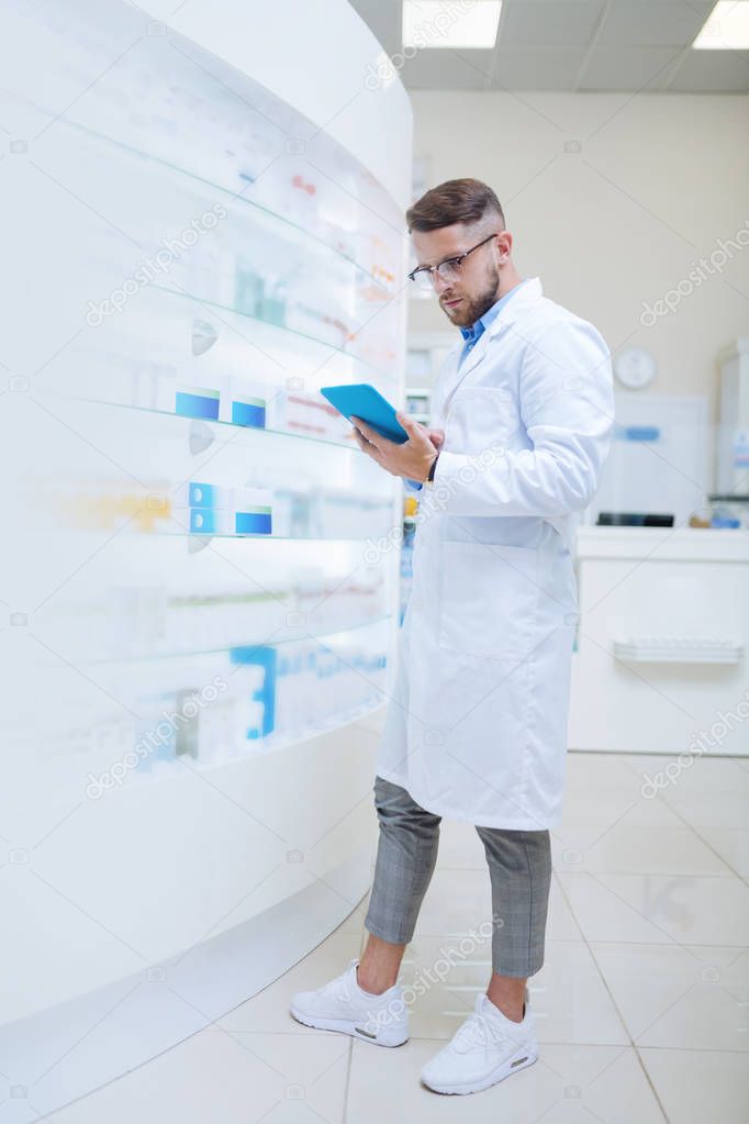 Handsome brunette male person doing pills inventory