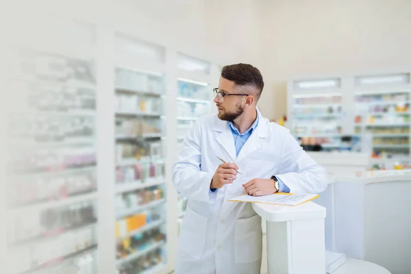 Químico barbudo serio que comprueba la variedad de medicamentos —  Fotos de Stock