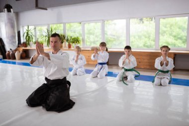 Aikido öğretmen ve çocuklar eğitim öncesi Namaste işareti yapma
