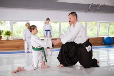 Kız onu eğitmen ile aikido pratik için hazırlanıyor