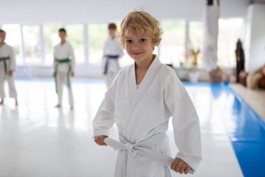 Sevimli kıvırcık sarı saçlı çocuk aikido ders katılıyor