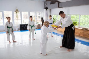 Sevimli sarı saçlı çocuk onun aikido öğretmen sarı kuşak alarak