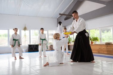 Sarışın çocuk antrenör kemer alırken diz üzerinde duran