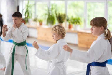 Erkek ve kız beyaz kimono giyen aikido pratik