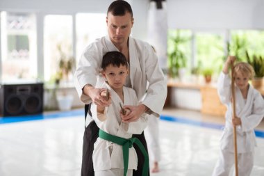 Genç aikido öğretmen Japon silah kullanarak çocuk yardım