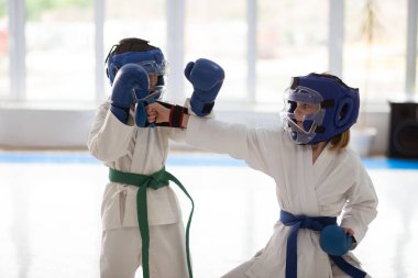 Beyaz kimono giyen erkek ve kız birlikte dövüş sanatı pratik