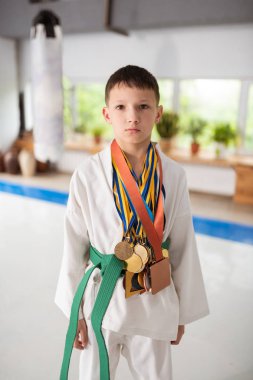Aikido'nun boynuna madalya takan koyu saçlı çocuk