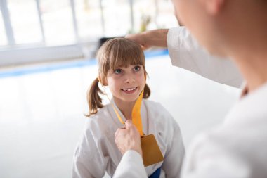 Madalya alırken gülümseyen beyaz kimono neşeli kız