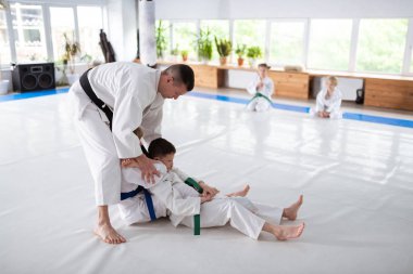 Öğrencilerine aikido öğreten beyaz kimono giyen eğitmen