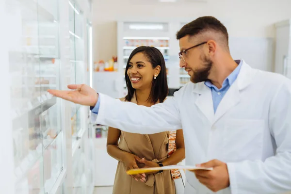 Jovem feliz pessoa feminina ouvindo farmacêutico — Fotografia de Stock