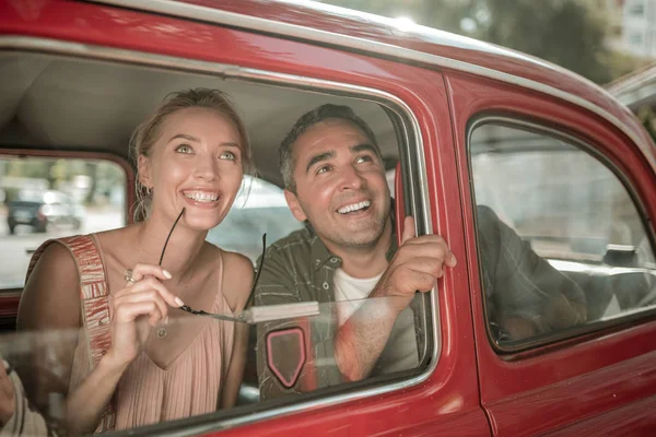 Casal alegre olhando pela janela do carro . — Fotografia de Stock