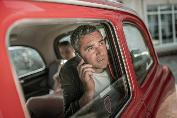 Homme parlant au téléphone assis dans la voiture . — Photo