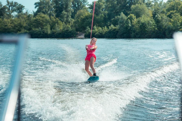 Leende långhårig ganska ung kvinna rider en wakeboard — Stockfoto