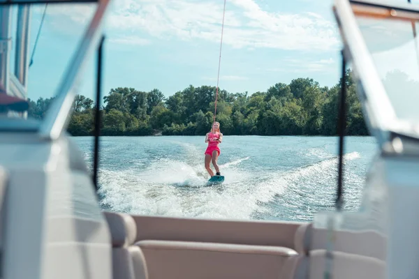 Fille chevauchant un wakeboard sur une rivière locale — Photo