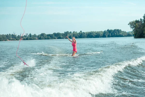 Lycklig kvinnlig wakeboarder stående knä-djupt i vattnet — Stockfoto