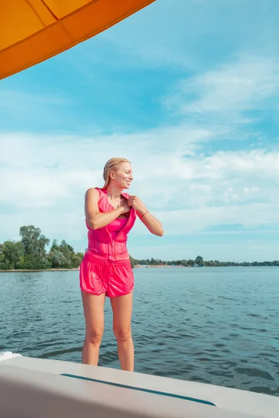 Sonriente rubia de pelo largo joven con ropa mojada —  Fotos de Stock