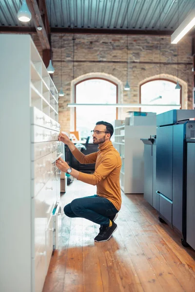 Homem usando óculos à procura de papel no escritório de impressão — Fotografia de Stock