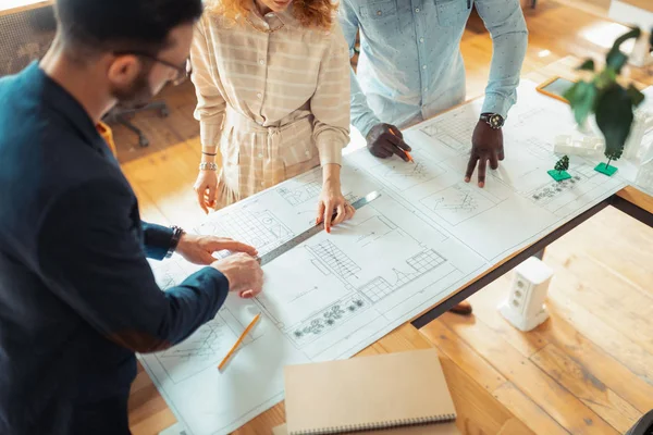 Tres diseñadores de interiores dibujando bocetos para un nuevo proyecto — Foto de Stock