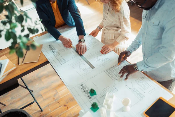 Top uitzicht van mannen en vrouwen samenwerken tijdens het tekenen schetsen — Stockfoto