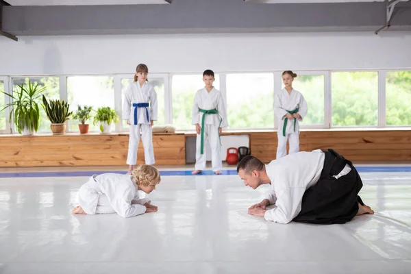 Blonder Junge und Aikido-Trainer verbeugen sich vor dem Kampf — Stockfoto