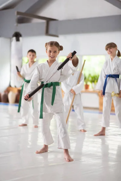 Menina em kimono branco praticando com nunchucks — Fotografia de Stock