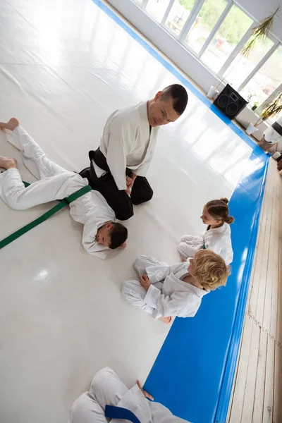 Top view of children watching their trainer doing hack on boy — Stock Photo, Image
