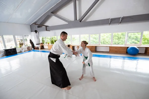 Girl wearing white kimono having fight with trainer — Stock Photo, Image