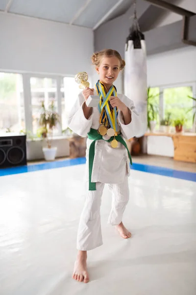 Menina vestindo quimono mostrando seu prêmio e medalhas — Fotografia de Stock