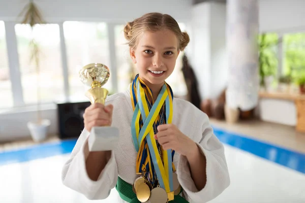 Happy talented girl practicing aikido showing her awards — Stock Photo, Image