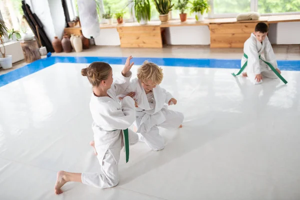 Junge und Mädchen im weißen Kimono kämpfen beim Üben — Stockfoto