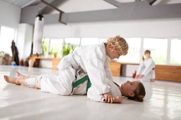 그녀와 함께 aikido 싸움을 승리 한 후 소녀에 앉아있는 소년 — 스톡 사진