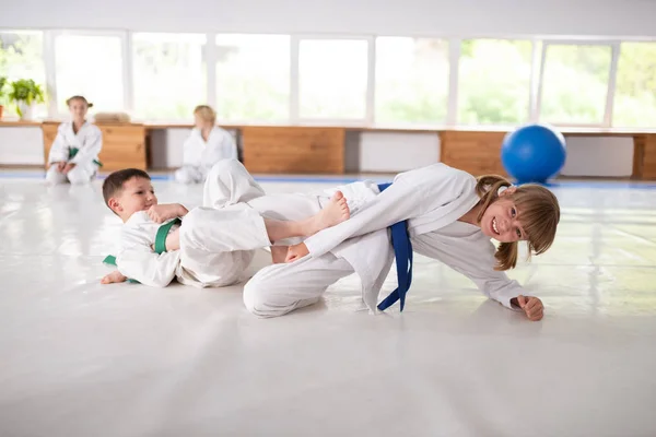 Boy and girl having aikido fight in sport school — Stock Photo, Image
